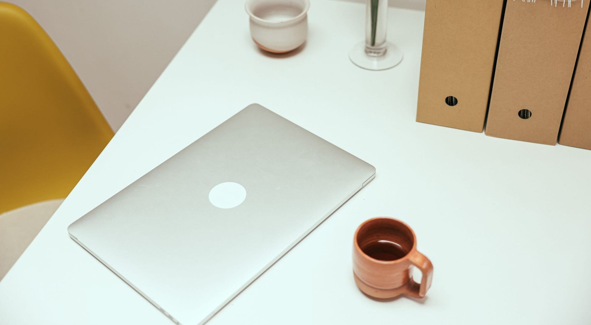 Soft daylight across a tidy desk with documents and a folder ready to be sorted — calm and prepared.